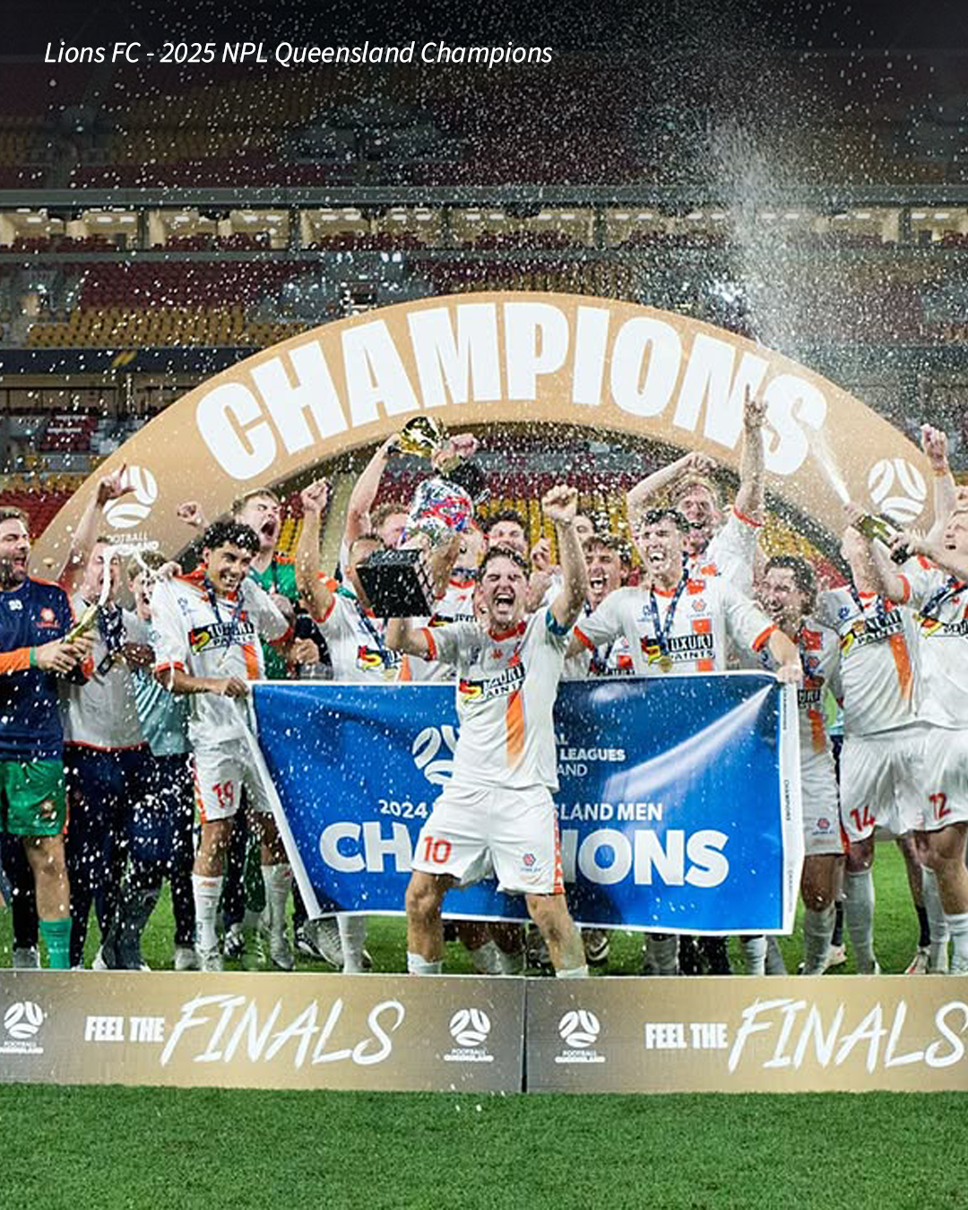 A Brisbane football team celebrating a championship win with players holding a “Champions” banner.